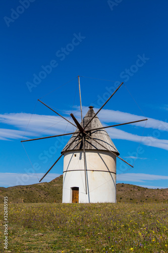 old windmill traditional in Spain, Pozo de los Frailes, province of Almeria, windmill under blue sky, traditional white windmill