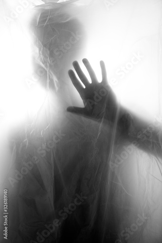 Dark figure behind plastic sheet, horror image