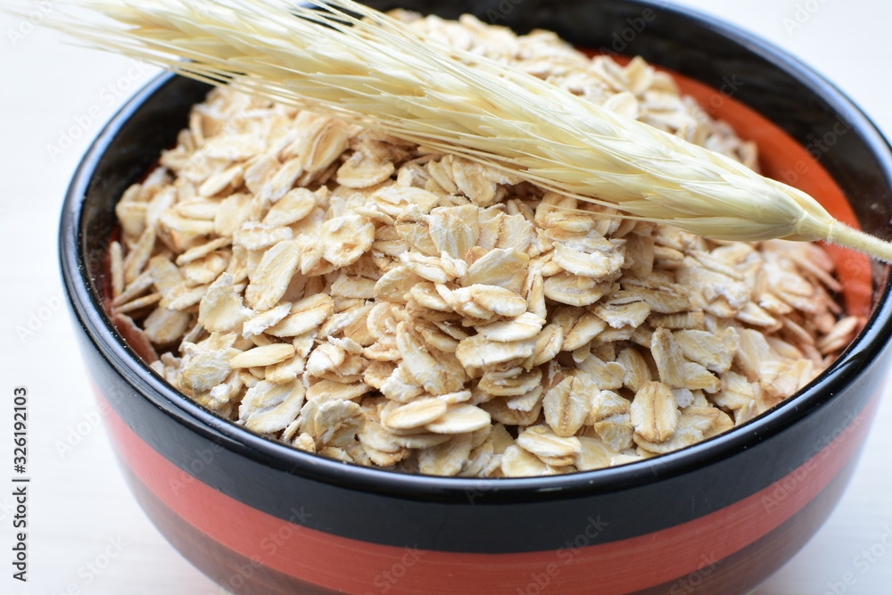 Oat grains and flakes accompanied by wheat ears in containers for display Oat grains and flakes accompanied by wheat ears in containers for display