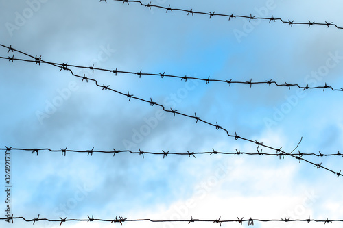 Barbed wire on a backgroung of blue sky