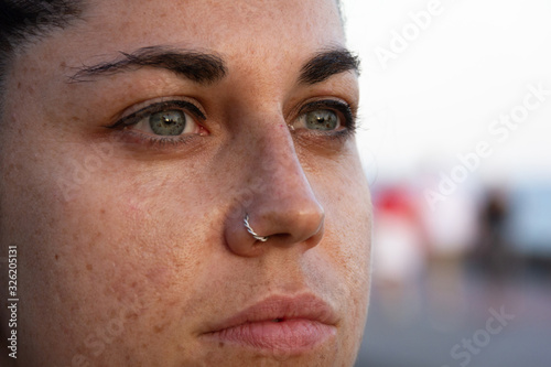 Φωτογραφία Extreme closeup of girl with freckles on face, green eyes and piercing on nose
