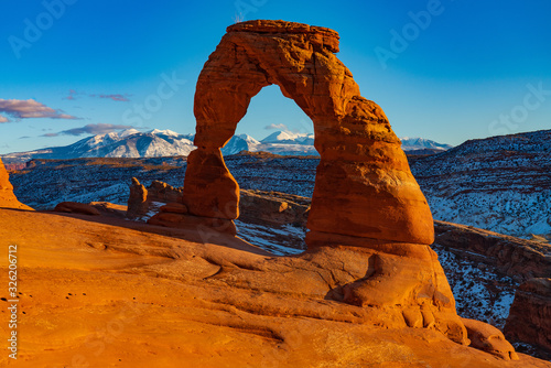 The Sun Illuminates Delicate Arch and the Snow Covered La Salle Mountains