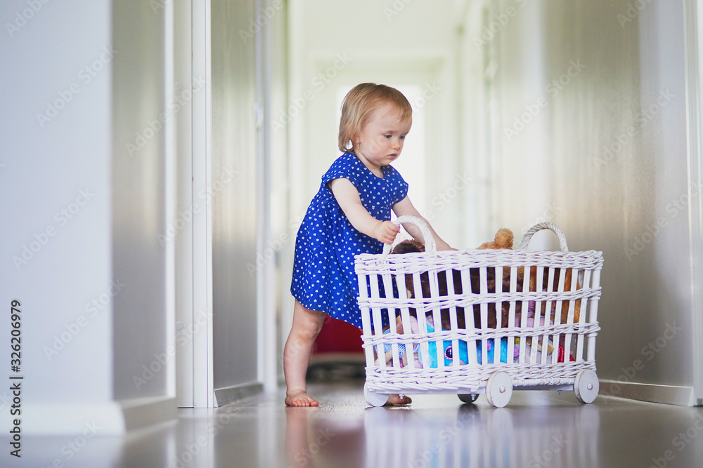 Adorable baby girl in blue dress playing with toys Adorable baby girl in blue dress playing with toys