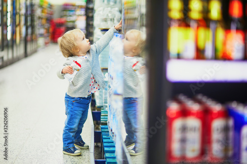 Little child going shopping in supermarket