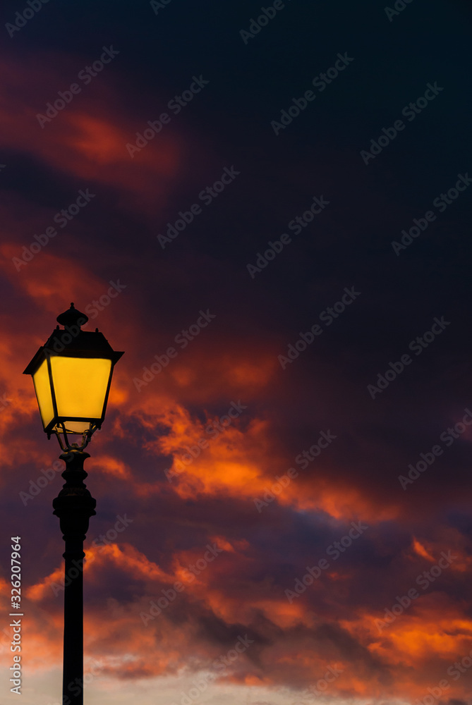 Old fashioned street lamp against beautiful sunset sky and colorful clouds (with copy space) Old fashioned street lamp against beautiful sunset sky and colorful clouds (with copy space)