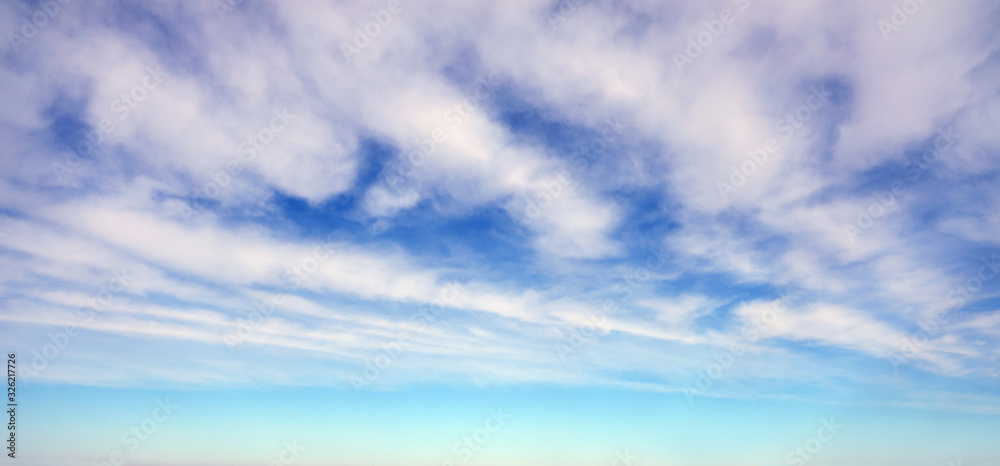  Light blue sky background with white striped clouds.