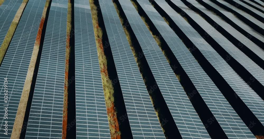 Aerial view flying over a solar farm, drone view of an endless solar panel array, the green energy future is here