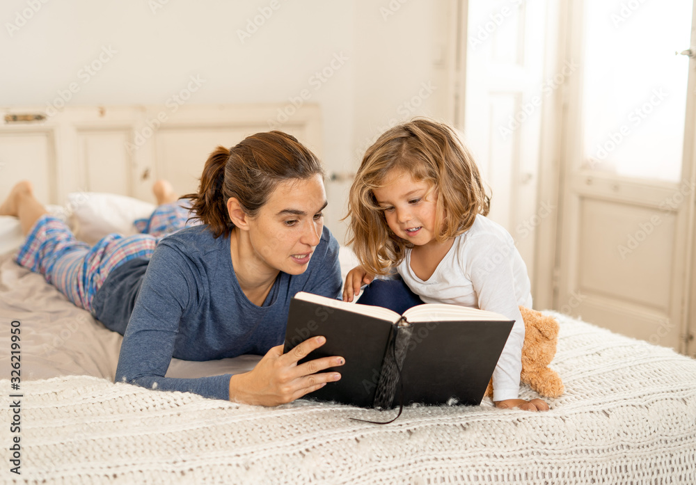 Mother and cute young daughter reading a book together Mother and cute young daughter reading a book together