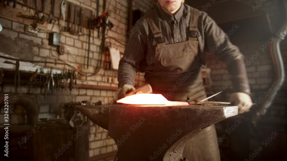 A man blacksmith heating the knife and forming it in right shape