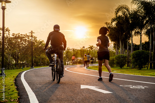 Lover ride on bike and run on the road in the park.