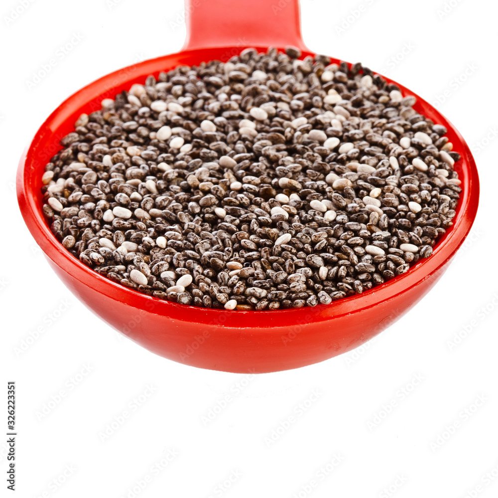 Chia seeds in a red plastic spoon isolated on a white background. Chia seeds in a red plastic spoon isolated on a white background.
