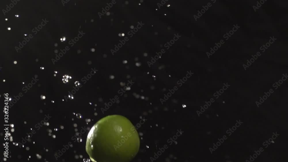 Lime throw up with water splash droplets slow motion closeup on black background macro shot cooking video Lime throw up with water splash droplets slow motion closeup on black background macro shot cooking video