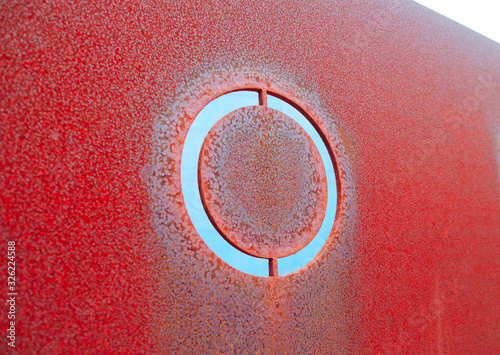 Single capital letter O cut out in rusty metal plate, angled perspective view. photo
