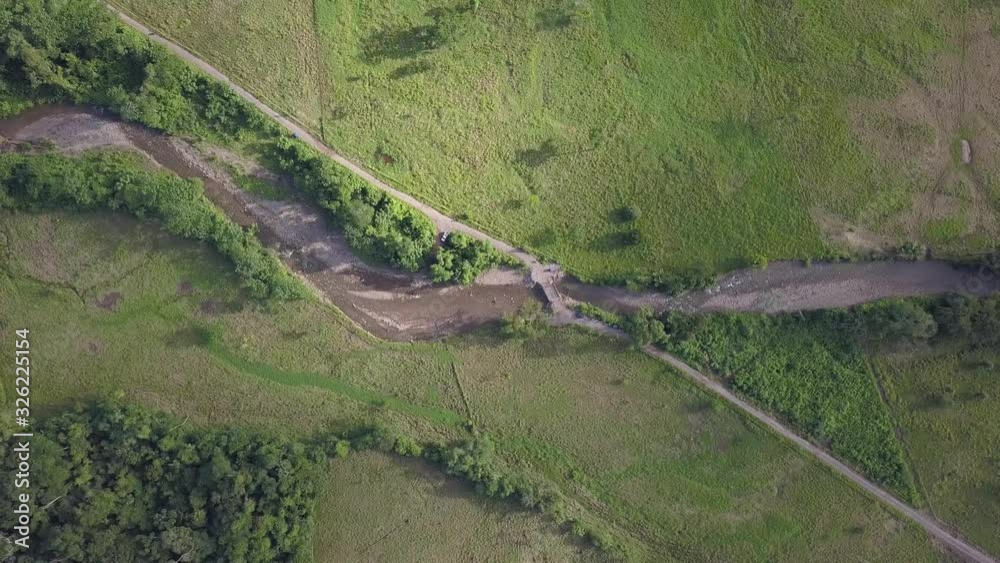aerial view from the top of a river crossed by a path made by man aerial view from the top of a river crossed by a path made by man