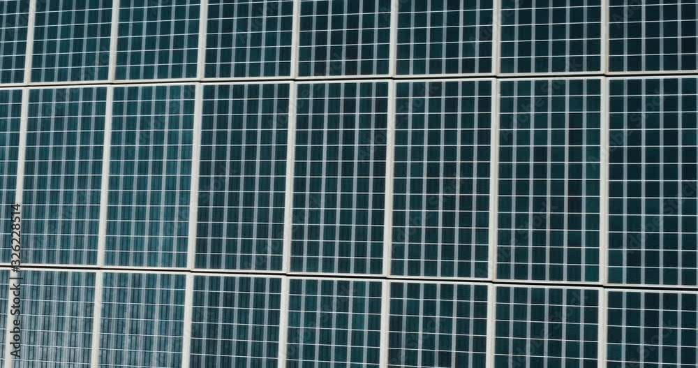 Aerial view flying over an endless array of solar panels on a solar power farm, the green renewable energy future is here Aerial view flying over an endless array of solar panels on a solar power farm, the green renewable energy future is here