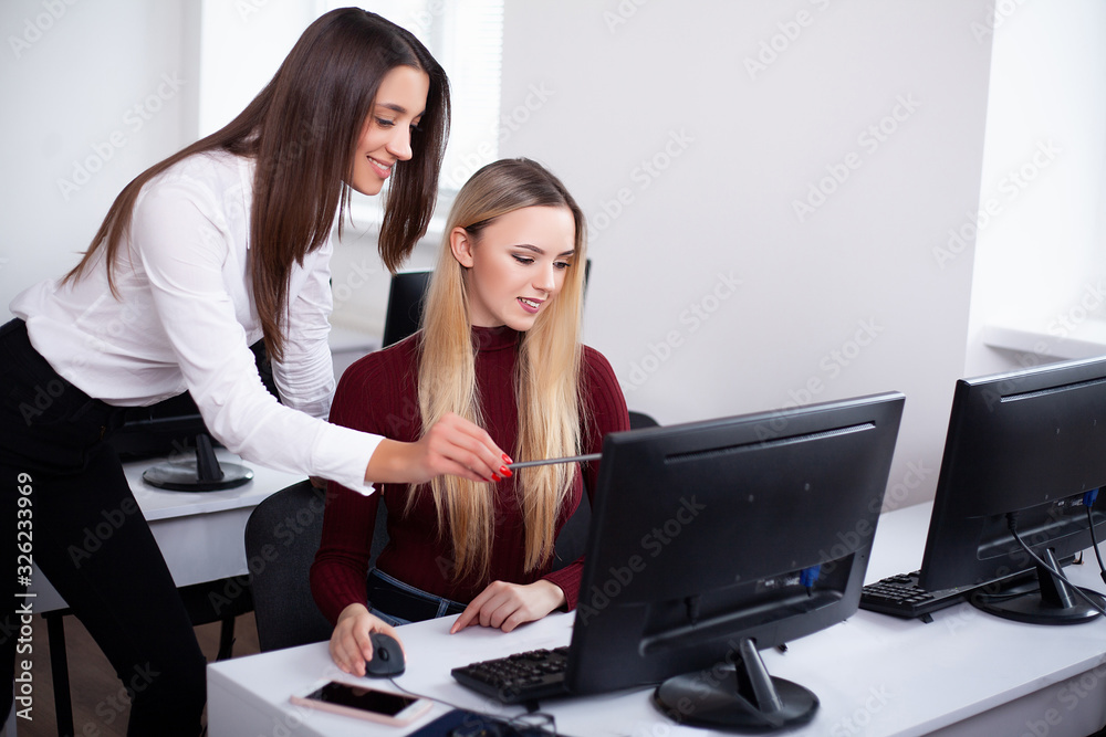 Two female colleagues in office working together. Two female colleagues in office working together.