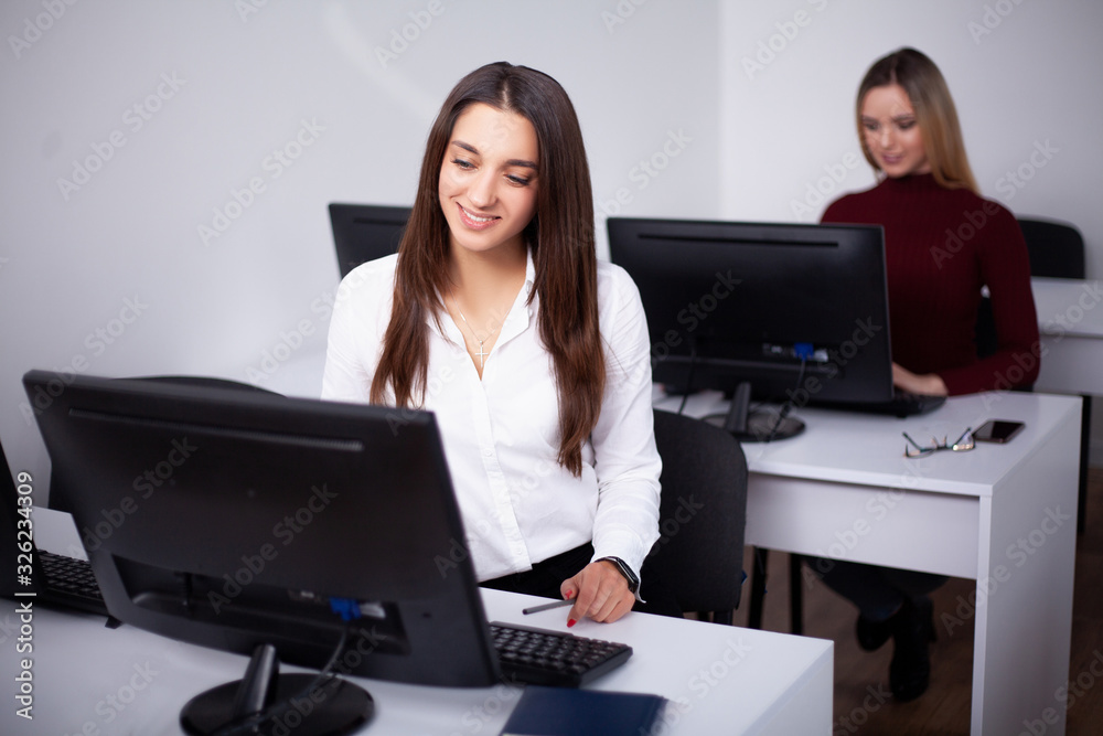 Two female colleagues in office working together. Two female colleagues in office working together.