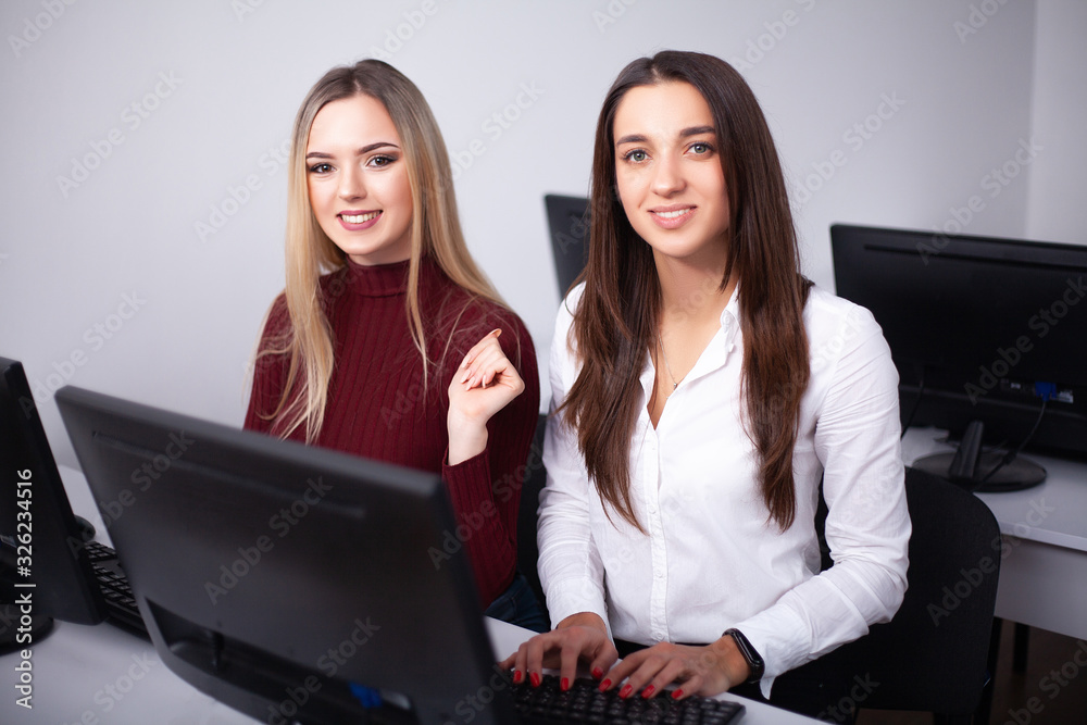 Two female colleagues in office working together. Two female colleagues in office working together.
