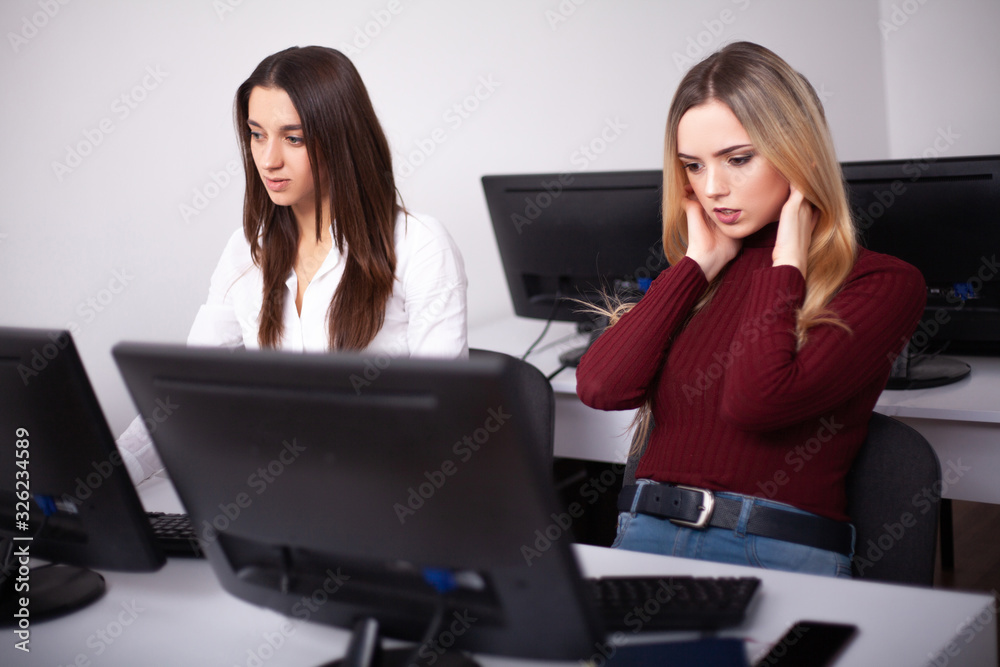 Two female colleagues in office working together. Two female colleagues in office working together.