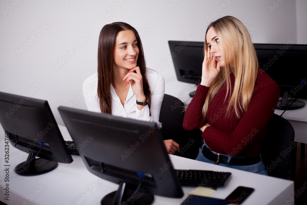 Two female colleagues in office working together. Two female colleagues in office working together.