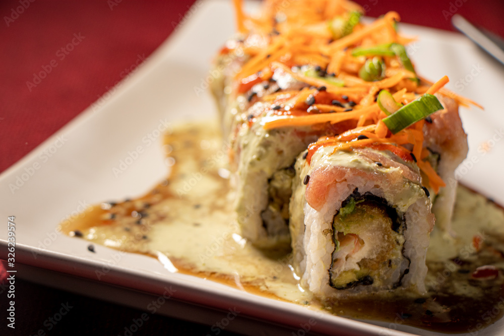 Sushi con camarón empanizado dentro y salmón con zanahoria rallada 