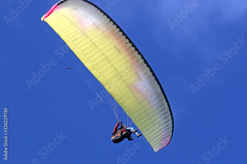 Tandem Paraglider flying wing in a blue sky	
