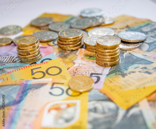 Australian notes and coins spilled out and stacked on a table. photo