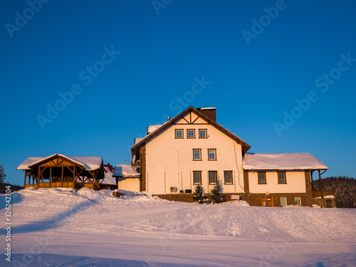 Alpine-style hotel house in the Gornaya Salanga ski resort. The sun rises. Beautiful morning lighting