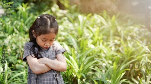 Asian kid  alone sad unhappy in garden