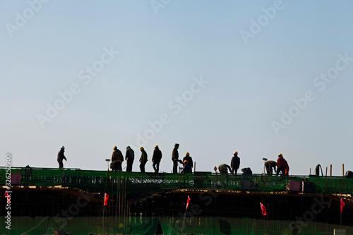 Reinforced concrete structure, the workers in the construction site in silhouette © pdm