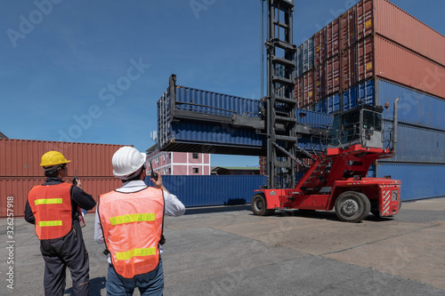 Foreman control loading containers box from cargo freight ship for import export, Foreman control industrial container cargo freight ship, Business import and export logistic concept.