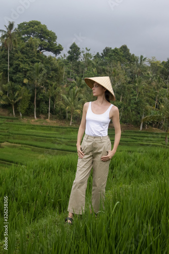 Woman wearing traditionl bamboo hat on the rice field terrace  © triocean