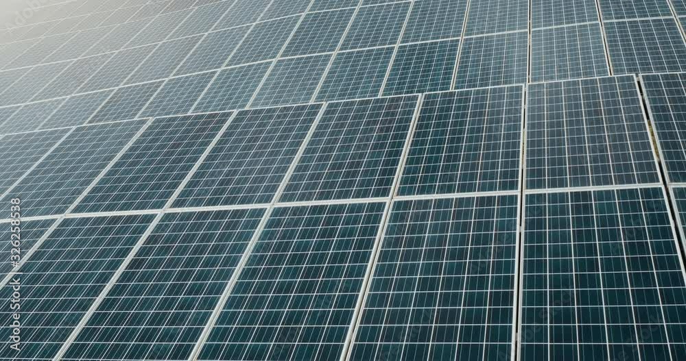 Aerial view of an endless array of solar panels generating energy from the sun on a solar farm, the renewable green energy future is here Aerial view of an endless array of solar panels generating energy from the sun on a solar farm, the renewable green energy future is here