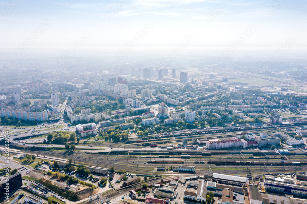 Aerial panoramic image of city industrial district. Buildings, plants, factories on blue foggy sky background