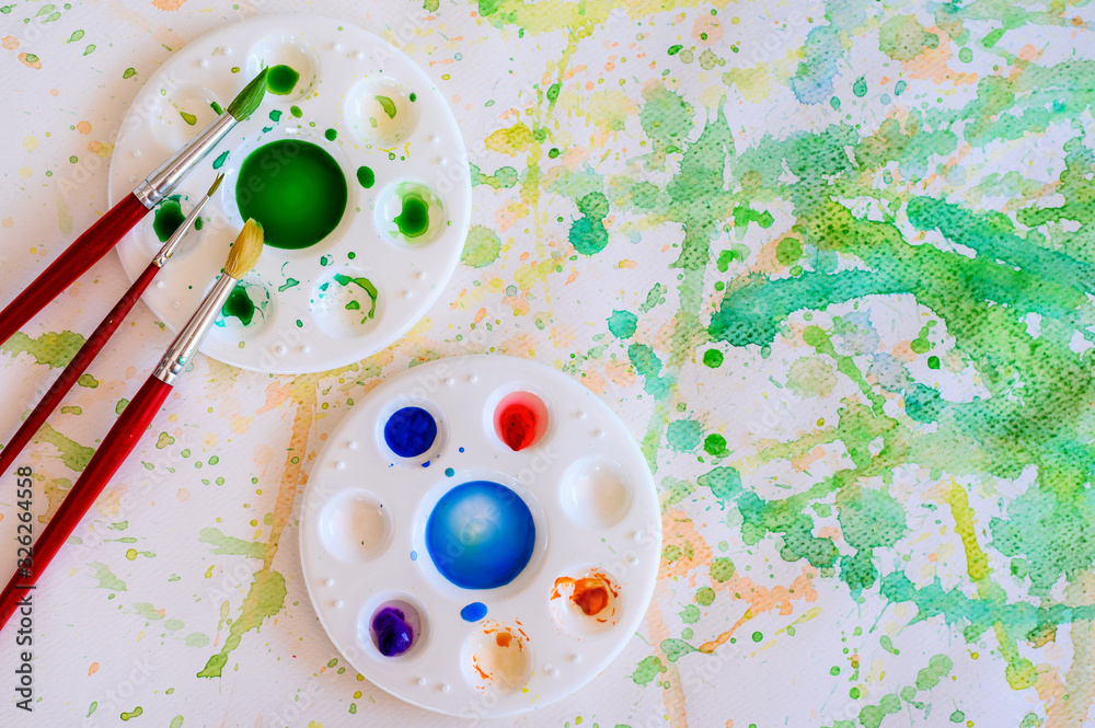 Φωτογραφία Paintbrush and watercolor paint, Palettes on the white paper smear the color, Education and art object, top view