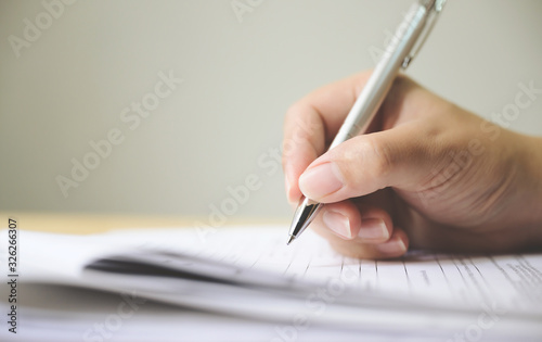 Hand of man signing signature filling in application form document