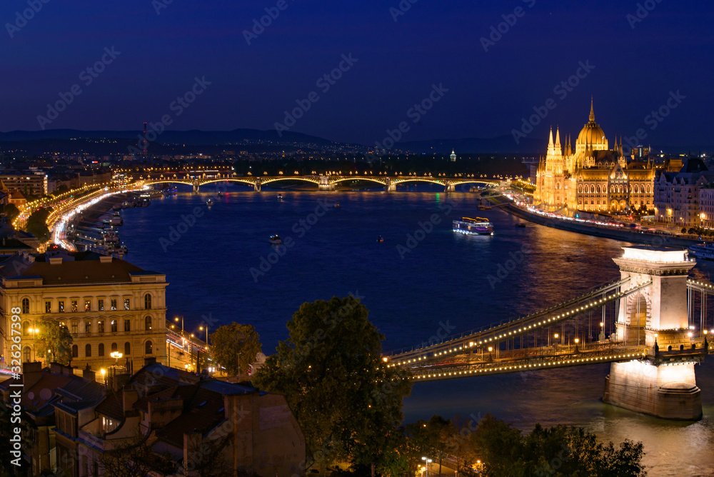 Night panorama of Hungarian Parliament Building, Széchenyi Chain Bridge, and River Danube in Budapest, Hungary