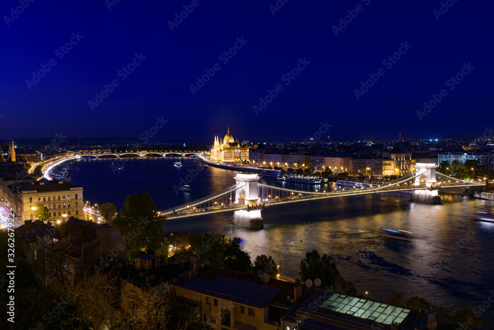 Night panorama of Hungarian Parliament Building, Széchenyi Chain Bridge, and River Danube in Budapest, Hungary