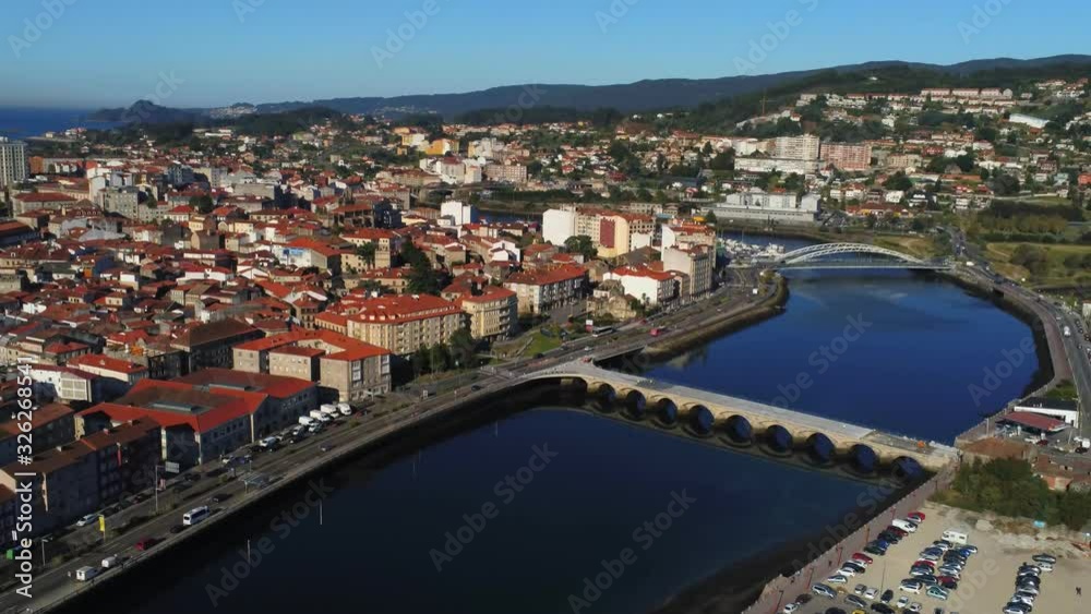 View of the Old bridge in Pontevedra city with buildings and river on a sunny day. Zoom out. Drone footage. Galicia, Spain View of the Old bridge in Pontevedra city with buildings and river on a sunny day. Zoom out. Drone footage. Galicia, Spain