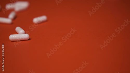 capsules, white tablets lie, roll on a red table, background, medicine, virus