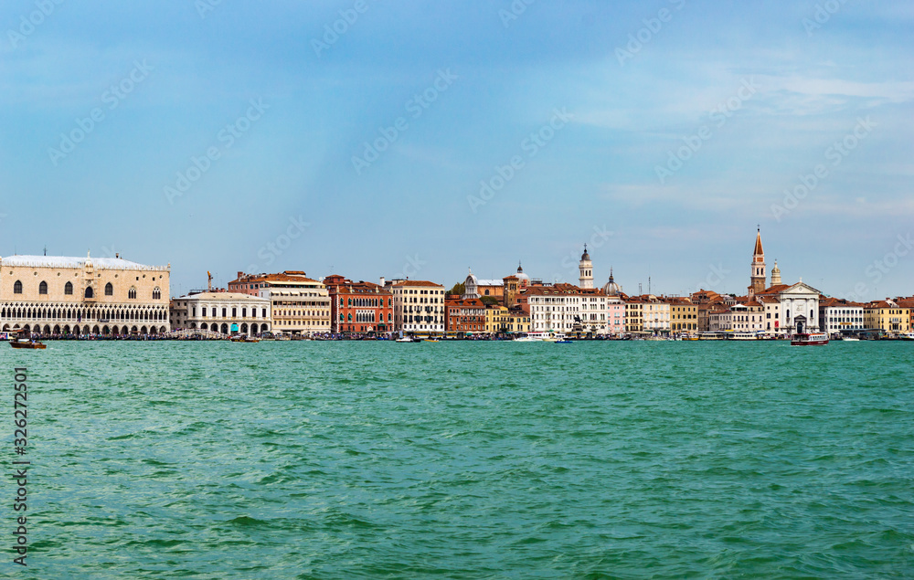 Venice, Italy - CIRCA 2013: Colorful buildings of Venice at a cloudy summer afternoon; as seen from Venice Lagoon.
