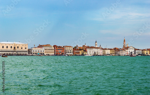 Venice, Italy - CIRCA 2013: Colorful buildings of Venice at a cloudy summer afternoon  as seen from Venice Lagoon. © HaniSantosa