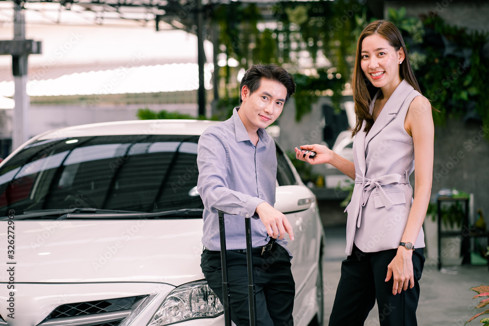Happy Asian couple getting great deal and complete agreement from car rental company officer.Young Asian couple  smiling woman getting keys of a new car.  Car rental successful concept.