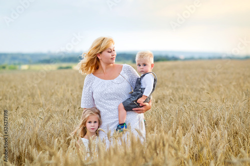 young woman, boy and girl in a wheat field