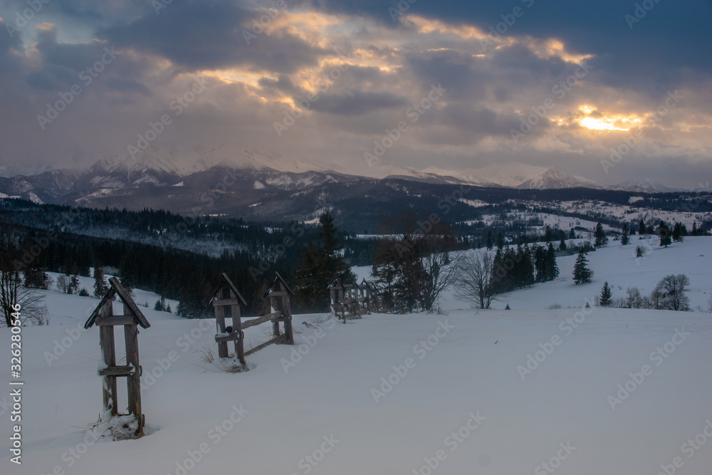 Beautiful snow clouds over the snow-covered peaks of the Tatra Mountains in the light of the setting sun