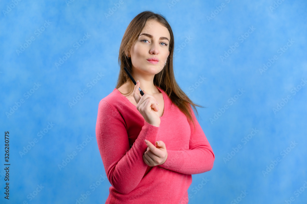 Portrait on a blue background of a serious pretty brunette Caucasian woman in a red sweater Portrait on a blue background of a serious pretty brunette Caucasian woman in a red sweater