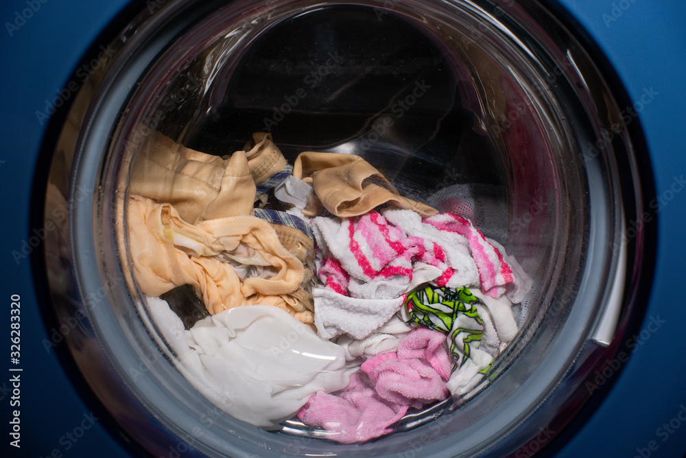 Laundry in the washing machine close-up. putting colored clothes in the washing machine. concept of washing, Laundry Laundry in the washing machine close-up. putting colored clothes in the washing machine. concept of washing, Laundry