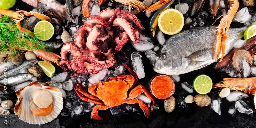 Seafood and fish flatlay. Sea bream, crab, sardines, scallop, octopus and caviar with lemon and lime Seafood and fish flatlay. Sea bream, crab, sardines, scallop, octopus and caviar with lemon and lime
