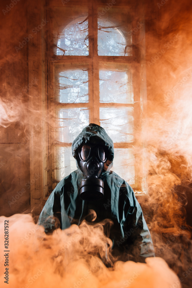Dramatic portrait of a female wearing a gas mask in a ruined building with  colorful smoke that looks like fire. Stock Photo | Adobe Stock