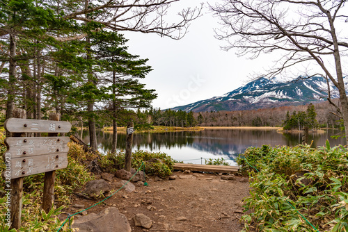 Hokkaido, Japan - May 06 2019 : The Second Lake of Shiretoko Goko Five Lakes area. Natural beauty scenery, mountain range and woodland in high latitude country springtime. Shiretoko National Park photo